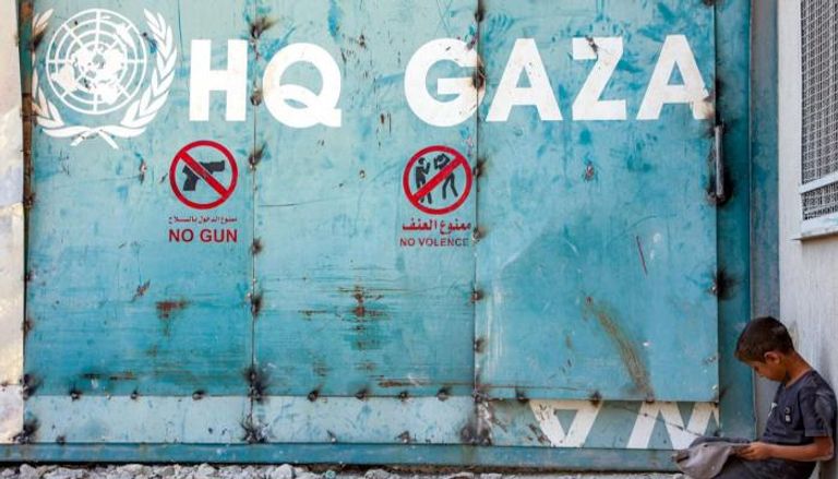 طفل يجلس أمام مدخل مبنى الأونروا في غزة