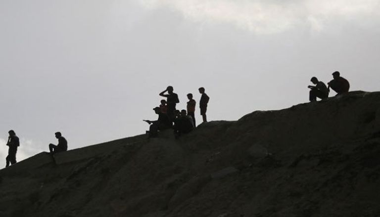نازحون يجلسون على تلة بجوار مخيم للنازحين في مخيم النصيرات للاجئين وسط غزة