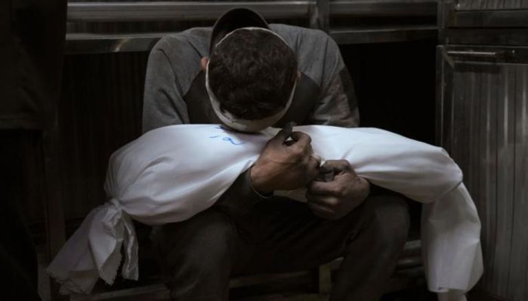 أب فلسطيني يحمل جثمان طفله في غزة