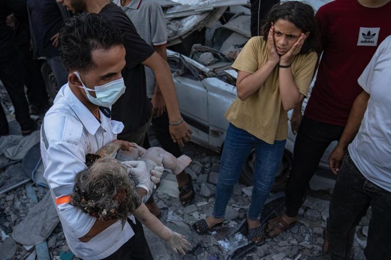 أب فلسطيني يحمل جثمان طفله في غزة