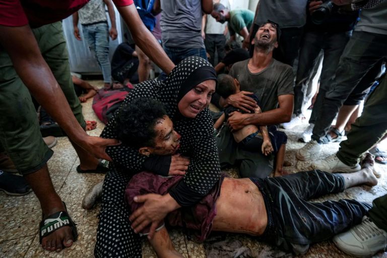 أب فلسطيني يحمل جثمان طفله في غزة