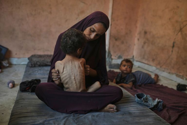أب فلسطيني يحمل جثمان طفله في غزة