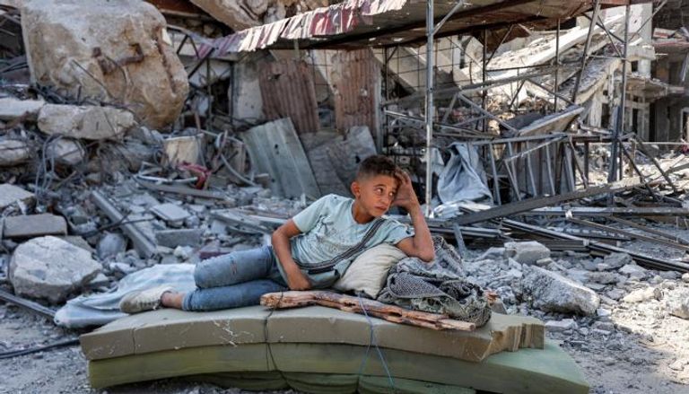 طفل فلسطيني وسط أنقاض مبنى بخان يونس