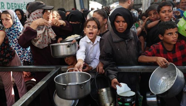 فلسطينيون يتجمعون لاستلام حصص غذاء من مطبخ خيري بغزة