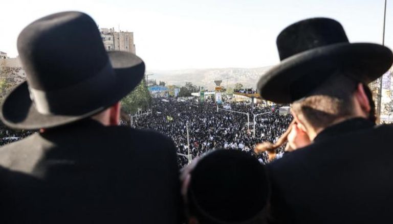 رجال من الحريديم ينظرون إلى الحشود في المظاهرة
