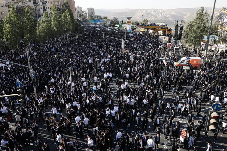رجال من الحريديم ينظرون إلى الحشود في المظاهرة