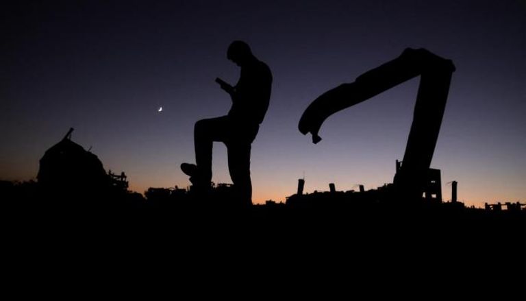 فلسطيني يقف أمام غروب الشمس في خان يونس