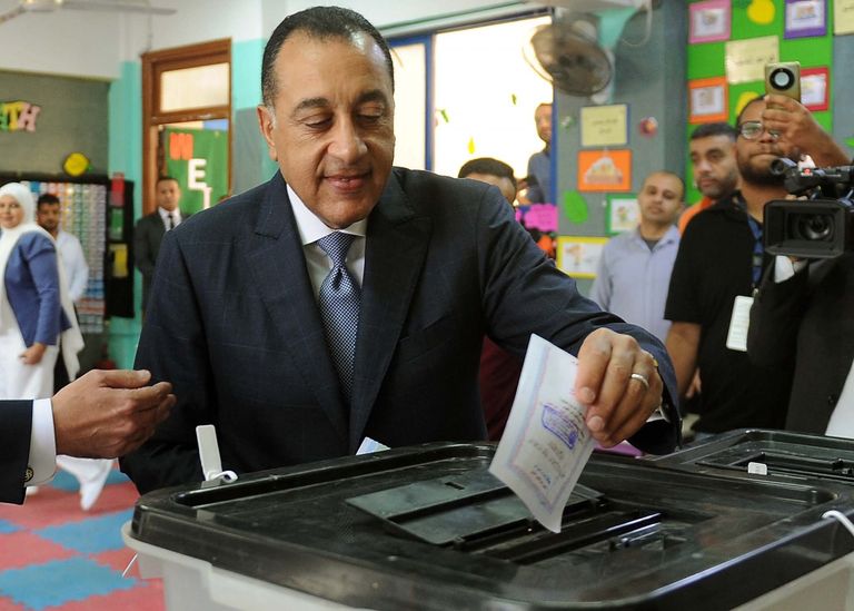 رجال شرطة يساعدون كبار السن للإدلاء بأصواتهم في الانتخابات