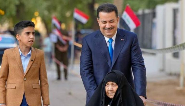 السوداني مصطحبا والدته إلى مركز الاقتراع