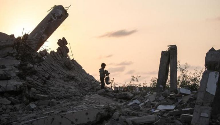 طفل فلسطيني يقف على ركام منزل عائلته في غزة