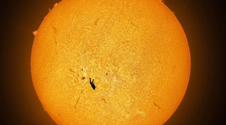 مصور يوثق صورة لمظلي يبدو وكأنه يسقط أمام سطح الشمس