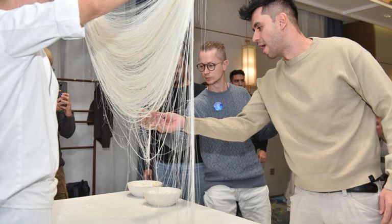 صانعو محتوى أجانب يلمسون نودلز رقيقة كالشعر مجموعة موعد مع الصين الإعلامية الدولية لعام 2025