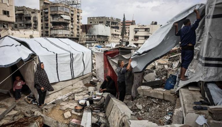 فلسطينيون يرممون خيامهم خشية الأمطار