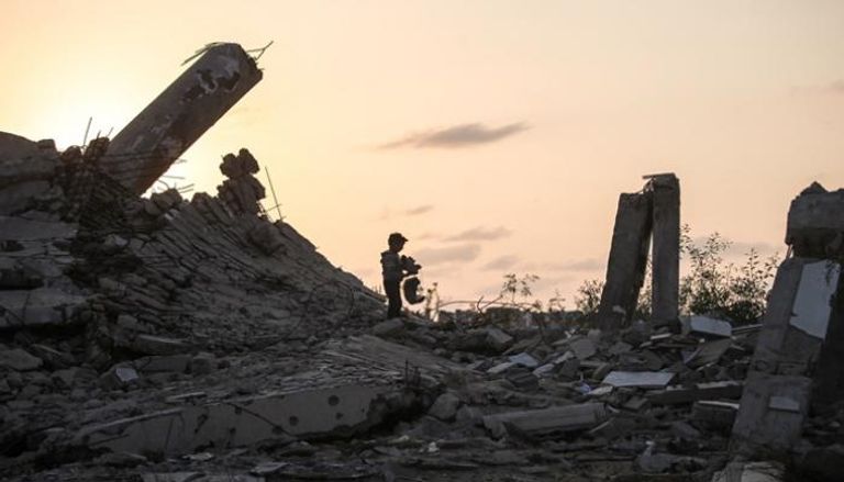 طفل فلسطيني يفتش في أنقاض المباني المهدمة بغزة