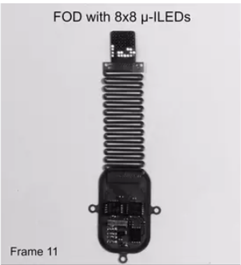 الجهاز اللاسلكي الرفيع والمرن مُثبت بجانب عملة معدنية صغيرة.