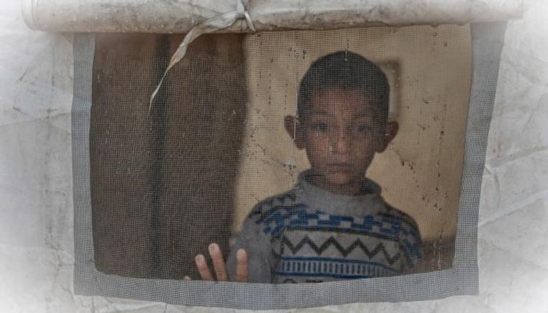 طفل ينظر من خيمة في حي الزيتون بمدينة غزة