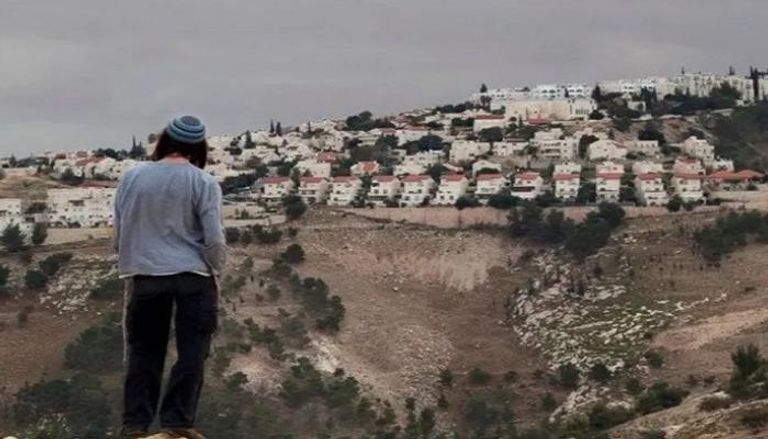 مستوطن يقف أمام بؤرة استيطانية في الضفة الغربية- أرشيفية