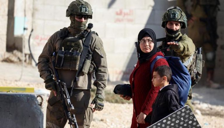 فلسطينية مع طفلها من مخيم «نور شمس»