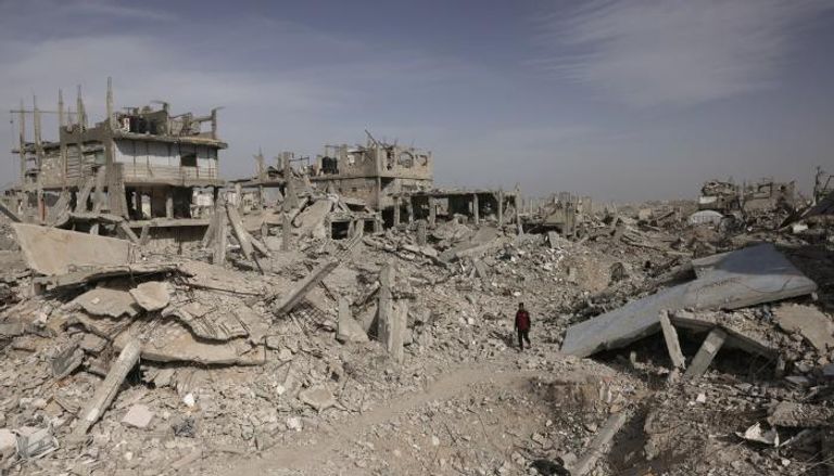 فلسطيني يسير بين الأنقاض في غزة