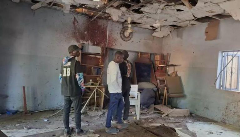 أشخاص يتفقذون موقع التفجير بالمسجد