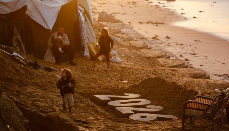 أطفال بجوار منحوتة 2026 في دير البلح