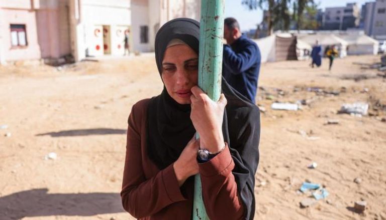 امرأة فلسطينية تبكي قرب جثامين أقاربها في غزة