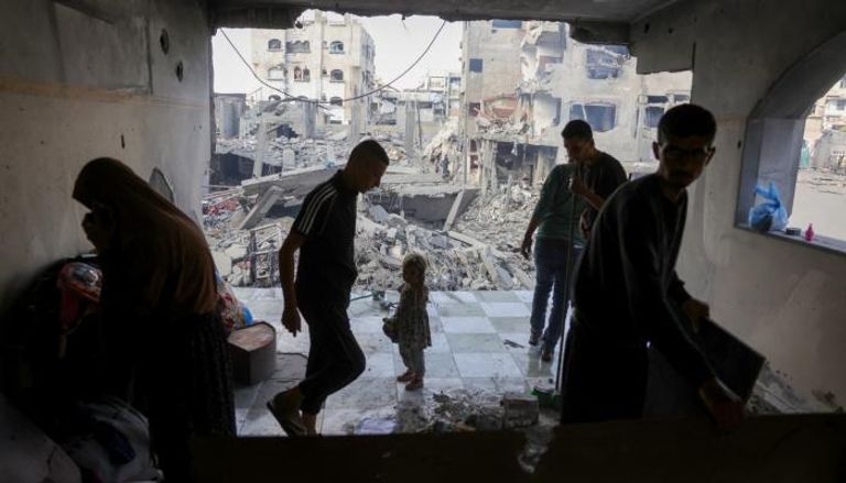 فلسطينيون يتفقدون موقع غارة إسرائيلية في جباليا