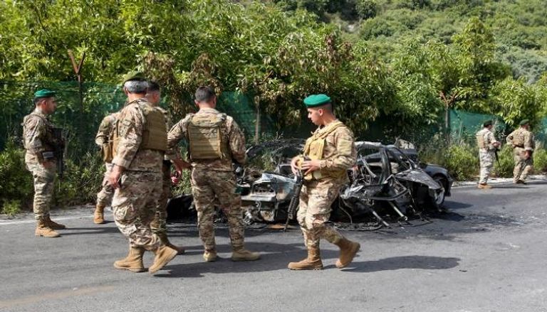 جنود لبنانيون بجوار مركبة قصفها الجيش الإسرائيلي