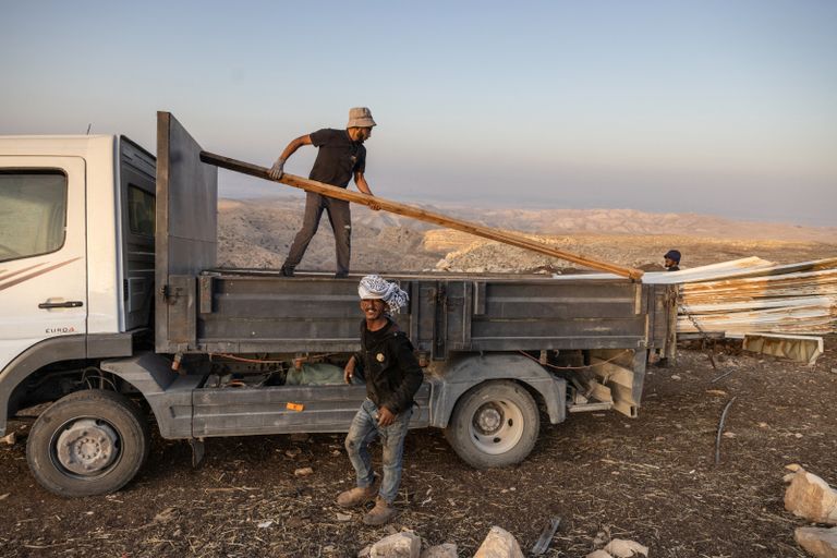 فلسطينيون يتفقدون مركبات أشعل فيها مستوطنون النار قرب سلفيت