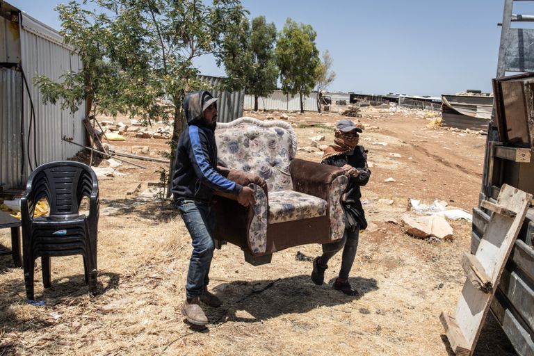 فلسطينيون يتفقدون مركبات أشعل فيها مستوطنون النار قرب سلفيت