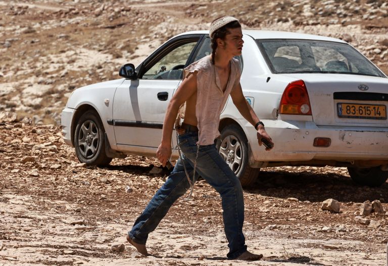 فلسطينيون يتفقدون مركبات أشعل فيها مستوطنون النار قرب سلفيت