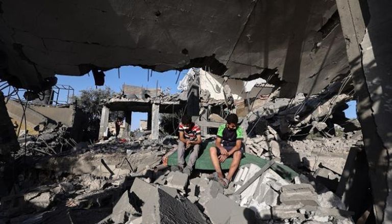 طفلان فلسطينيان يجلسان على أنقاض منزل
