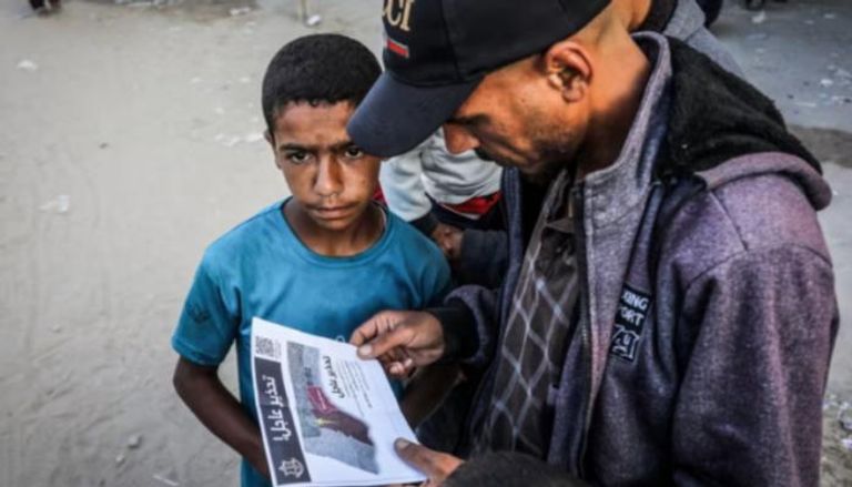 فلسطيني يقرأ منشور إخلاء