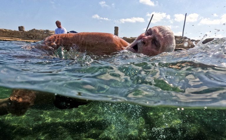 مسنون كوبيون يغطسون في مياه هافانا - أ ف ب