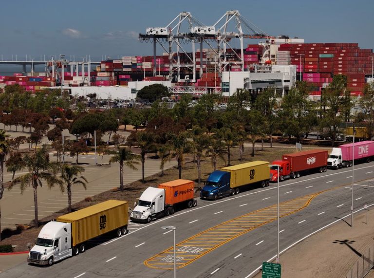 الرئيس الأمريكي دونالد ترامب وحاويات في خلفية الصورة - تعبيرية