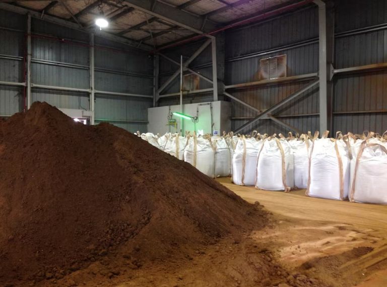 عمال ينقلون التربة التي تحتوي على عناصر أرضية نادرة للتصدير في ميناء صيني