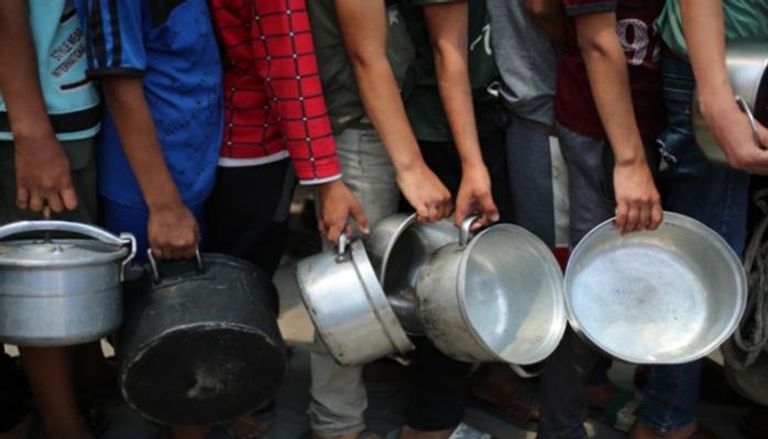 أطفال في طابور لتوزيع وجبات