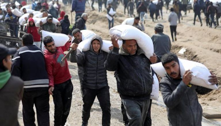 فلسطينيون من غزة يحملون مساعدات