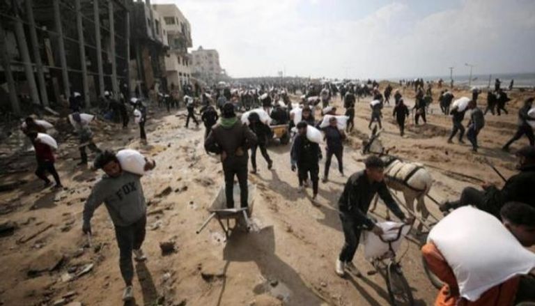 فلسطينيون من غزة يحملون مساعدات