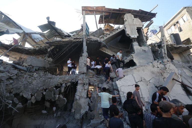 فلسطيني يفحص نفسه بحثًا عن جروح بينما يتصاعد الدخان بعد غارة إسرائيلية
