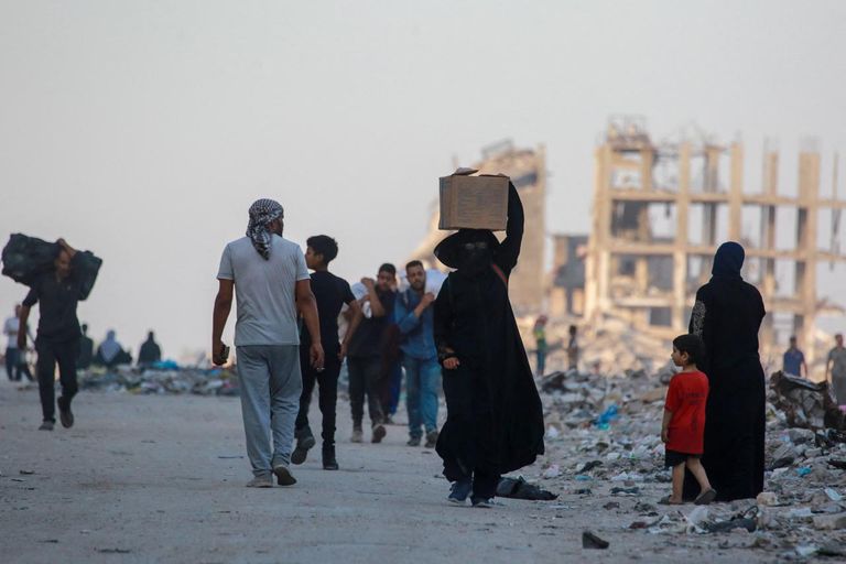 فلسطيني يفحص نفسه بحثًا عن جروح بينما يتصاعد الدخان بعد غارة إسرائيلية