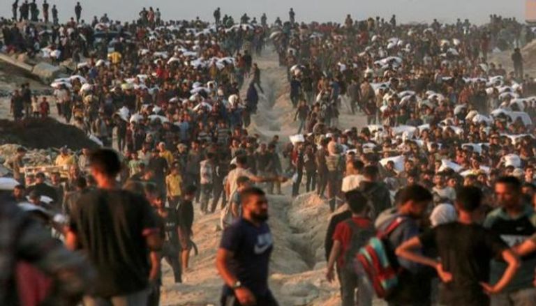 فلسطينيون يحملون أكياس الدقيق على طول شارع الرشيد غرب جباليا