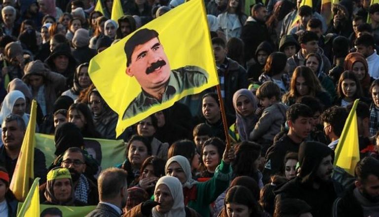 أكراد يلوحون بأعلام تحمل صور مؤسس حزب العمال الكردستاني أوغلان