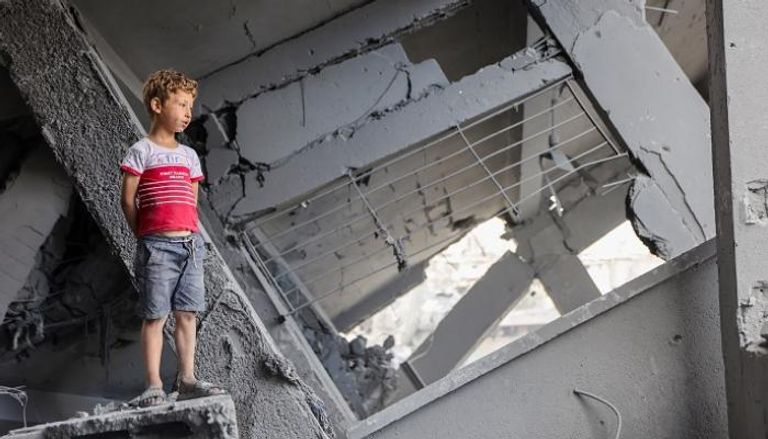 طفل فلسطيني فوق أنقاض أحد المنازل بغزة - أ.ف.ب