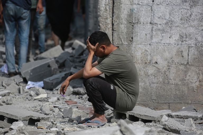 طفل فلسطيني فوق أنقاض أحد المنازل بغزة - أ.ف.ب