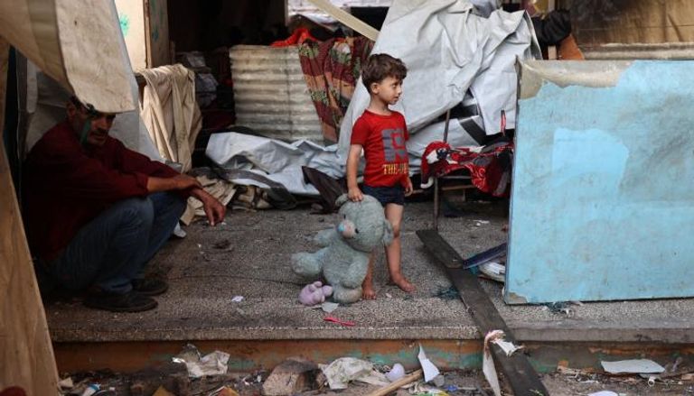 طفل ووالده بمدرسة للنازحين في غزة تعرضت للقصف