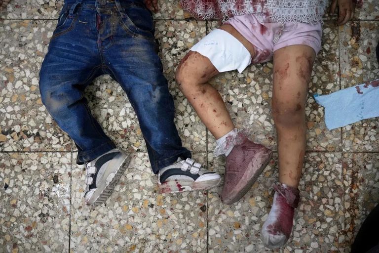 أم تحتضن طفلها أمام مستشفى شهداء الأقصى وسط القطاع