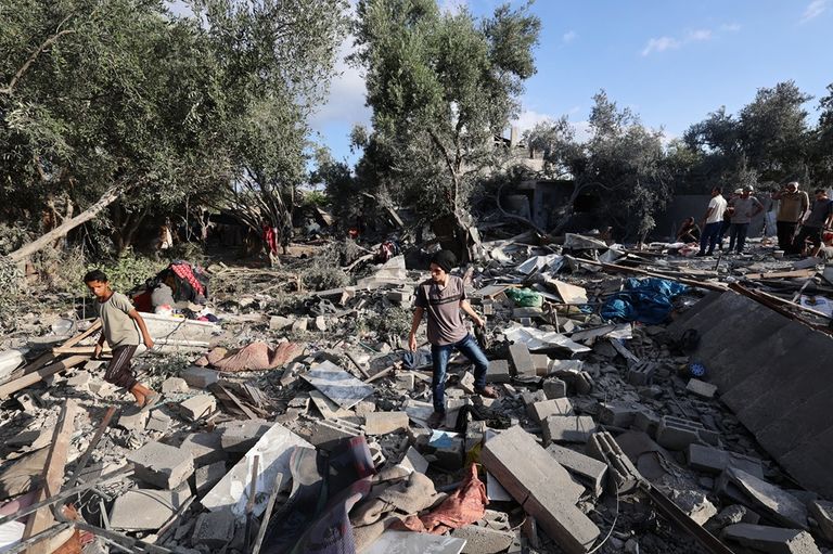 فلسطينيون فوق أنقاض منزل مدمر