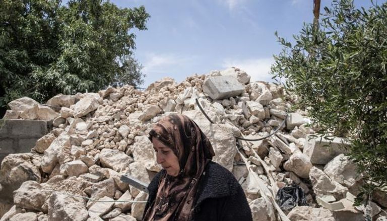 فلسطينية أمام منزل مدمر بالضفة الغربية