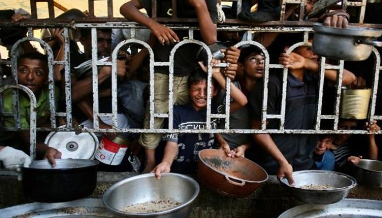 أطفال يتدافعون للحصول على الطعام في غزة